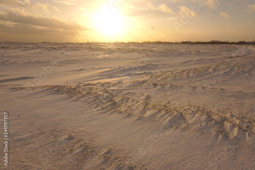 the field is covered with snow at sunset