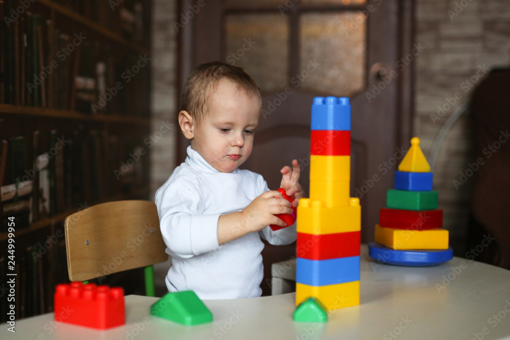 Toddler child builds tower sits at table Toddler child builds tower sits at table