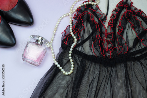 Sexy lingerie. Red and black lace, black shoes, pearl necklace and perfume on a light background. The concept of erotic linen, a date, a flat lay