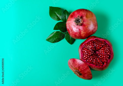 Εκτύπωση καμβά Pomegranate red fruit on green background, top view