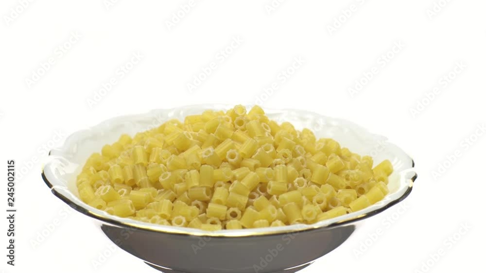Raw macaroni in rotation. Ditalini lisci. Close up. Raw pasta isolated on white. Italian cuisine concept. Raw macaroni in rotation. Ditalini lisci. Close up. Raw pasta isolated on white. Italian cuisine concept.
