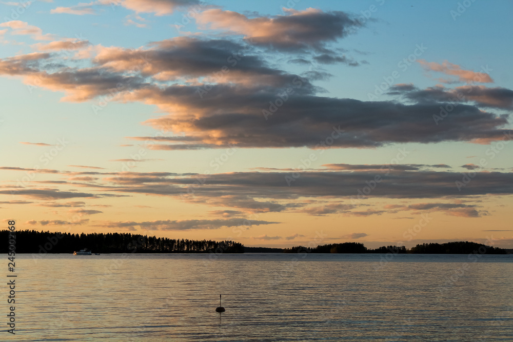 Sunset with dramatic clouds as seen from the shore of a Finish / Scandinavian lake during summer (Finland, Europe) Sunset with dramatic clouds as seen from the shore of a Finish / Scandinavian lake during summer (Finland, Europe)