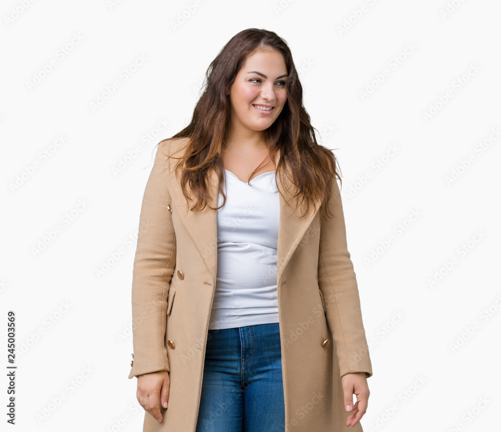 Beautiful plus size young woman wearing winter coat over isolated background looking away to side with smile on face, natural expression. Laughing confident.