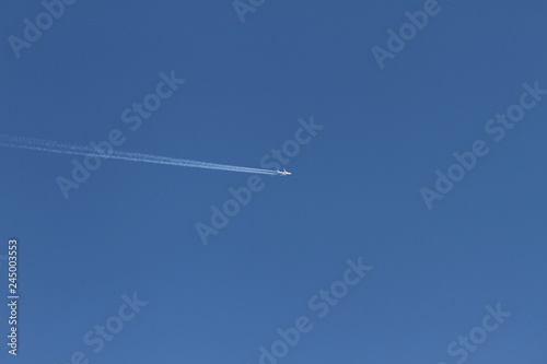 Airplane on a blue sky. Dream vacation concept. travel and tourism. Blue background texture. Wallpaper of airplane in the sky.