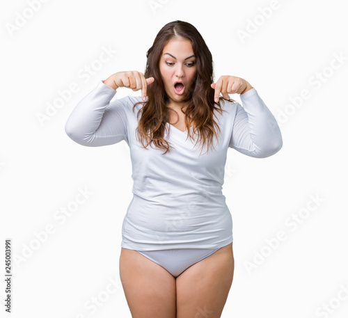 Beautiful plus size young overwight woman wearing white underwear over isolated background Pointing down with fingers showing advertisement, surprised face and open mouth © Krakenimages.com