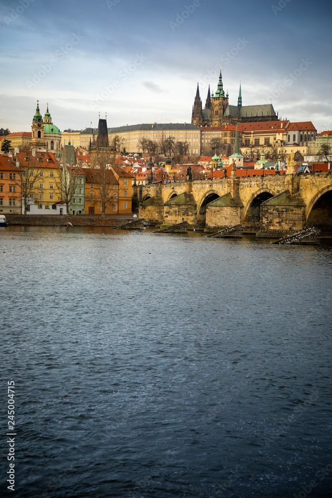 Panorama of Charles bridge and Prague castle over Vltava river in cloudy day, Czech Republic