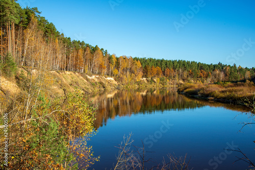 blue sky and clouds reflecting in calm water of river Gauja in latvia in autumn