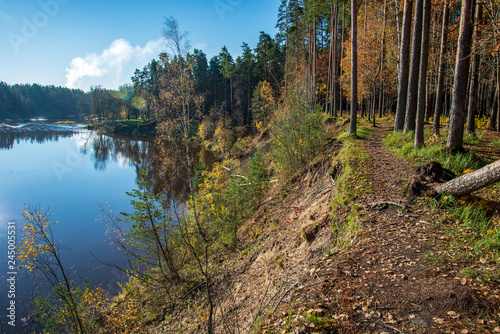 blue sky and clouds reflecting in calm water of river Gauja in latvia in autumn