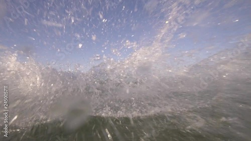 Kitesurfer jumps and splash of water goes into the camera