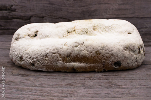Stollen (traditional German Christmas cake) on wooden background