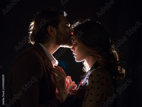 A man kisses a woman on the forehead