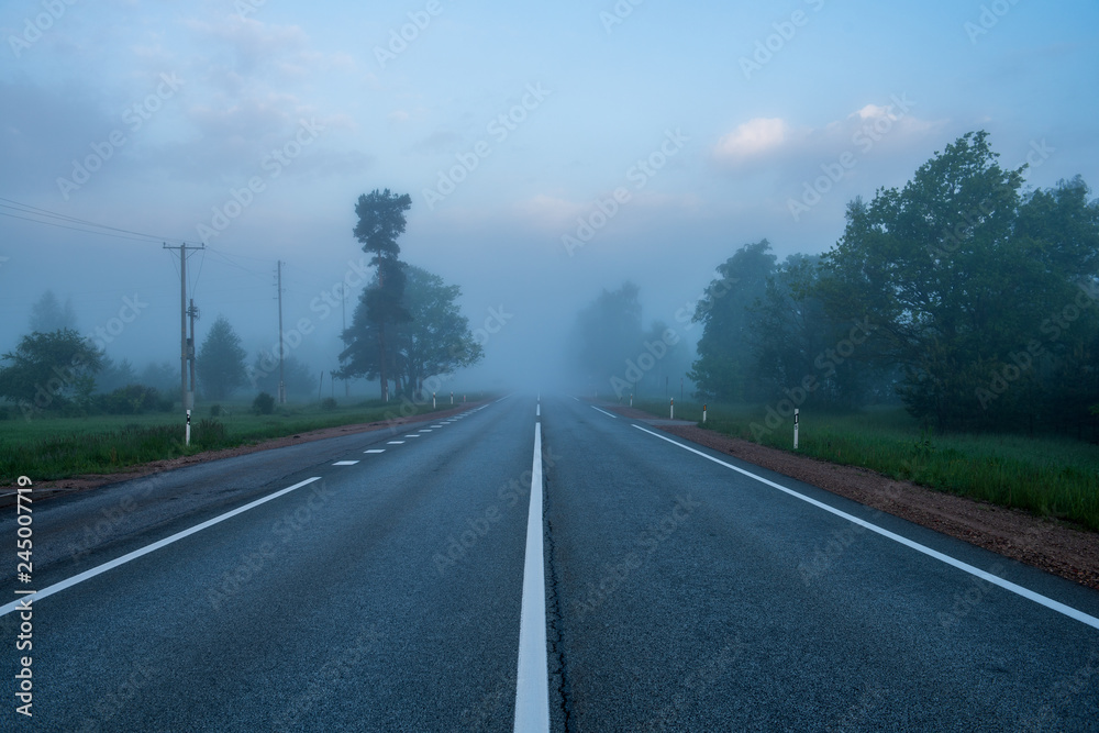 Naklejka premium empty asphalt road with white lines painted in misty morning