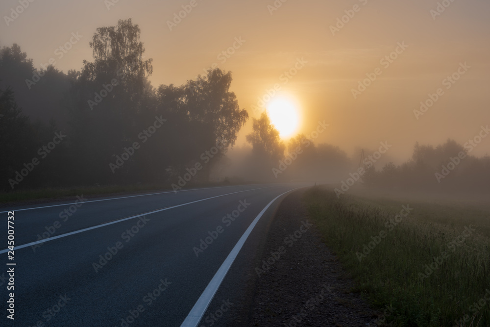 empty asphalt road with white lines painted in misty morning