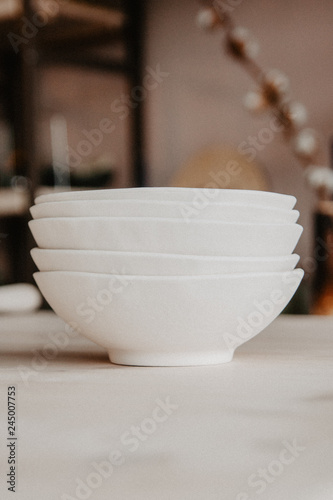 Fototapeta Naklejka Na Ścianę i Meble -  Stack of ceramic plates on cozy back