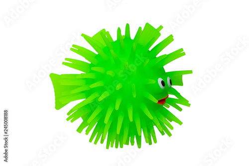Rubber toys. Funny green puffer fish made of rubber. Cute toy fish isolated on a white background. Macro.
