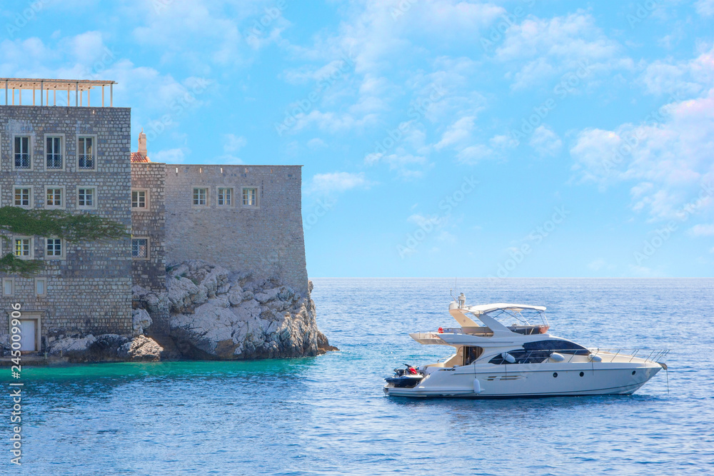 Part of the island of Sveti Stefan and sailing out of the Bay yacht, removed from the opposite shore Part of the island of Sveti Stefan and sailing out of the Bay yacht, removed from the opposite shore
