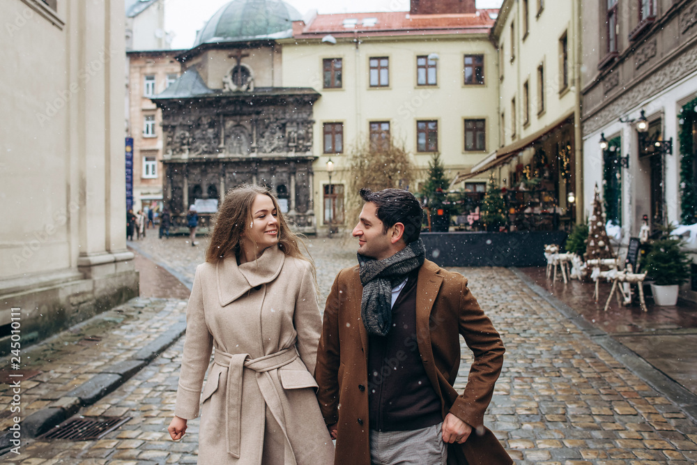 Beautiful lovely couple walking around the central old part of the Christmas Europe city