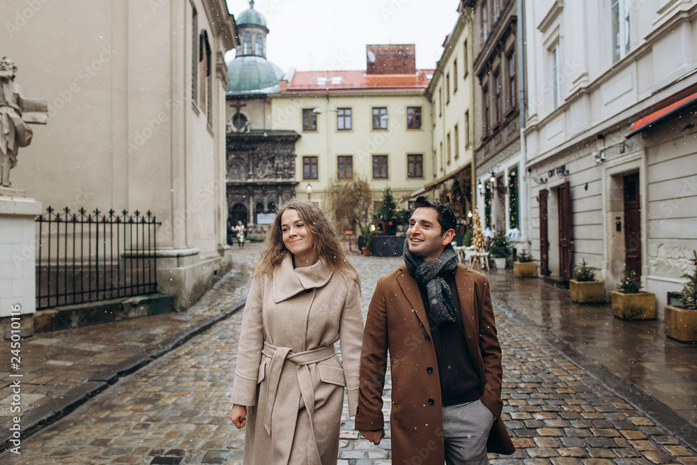 Beautiful lovely couple walking around the central old part of the Christmas Europe city