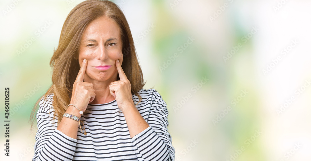 Beautiful middle age woman wearing stripes sweater over isolated background Smiling with open mouth, fingers pointing and forcing cheerful smile