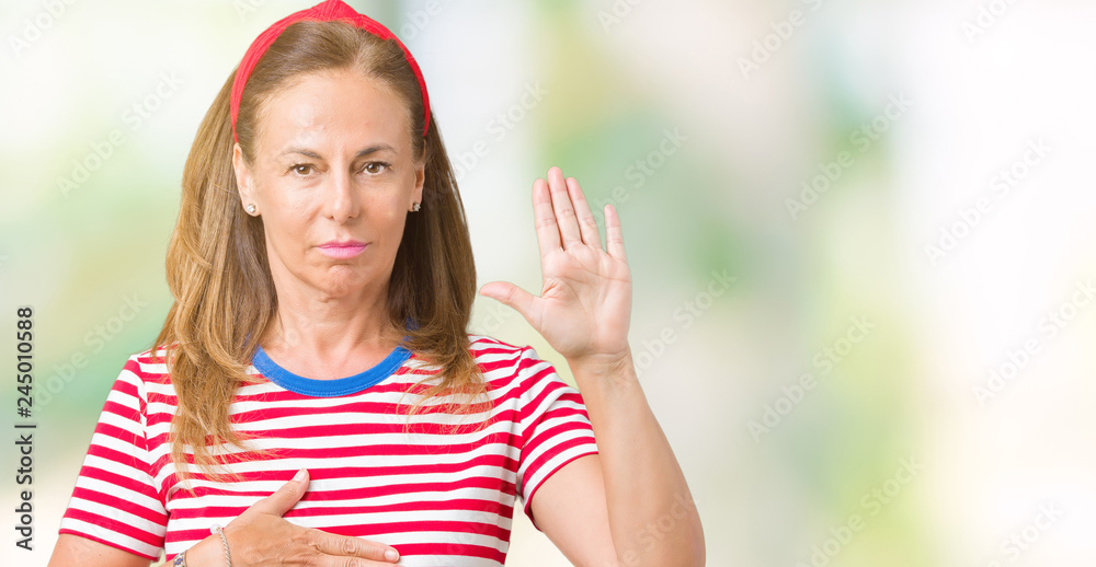Beautiful middle age woman wearing casual stripes t-shirt over isolated background Swearing with hand on chest and open palm, making a loyalty promise oath Beautiful middle age woman wearing casual stripes t-shirt over isolated background Swearing with hand on chest and open palm, making a loyalty promise oath