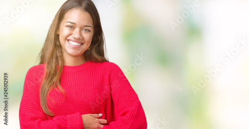 Young beautiful brunette woman wearing red winter sweater over isolated background Smiling and laughing hard out loud because funny crazy joke. Happy expression.