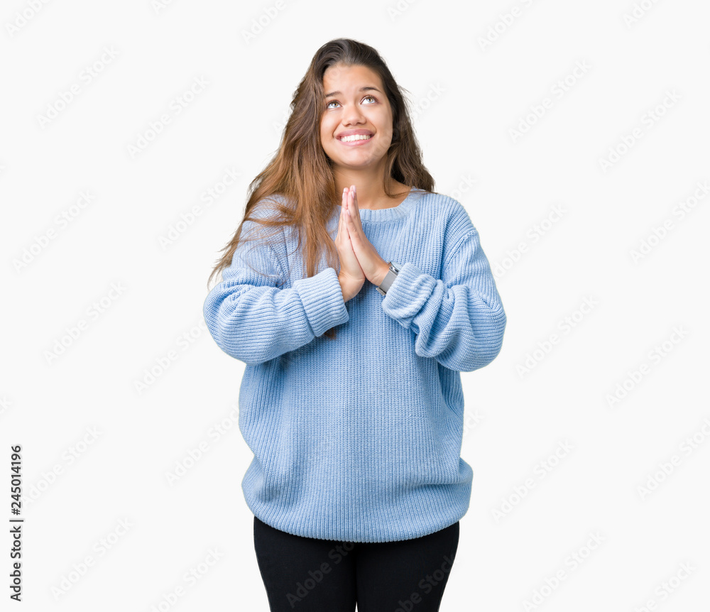Young beautiful brunette woman wearing blue winter sweater over isolated background begging and praying with hands together with hope expression on face very emotional and worried Young beautiful brunette woman wearing blue winter sweater over isolated background begging and praying with hands together with hope expression on face very emotional and worried