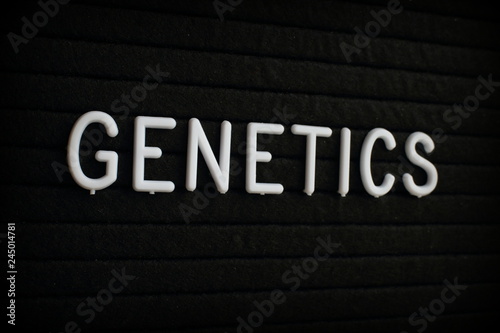 The word Genetics in white plastic letters on a black letter board 