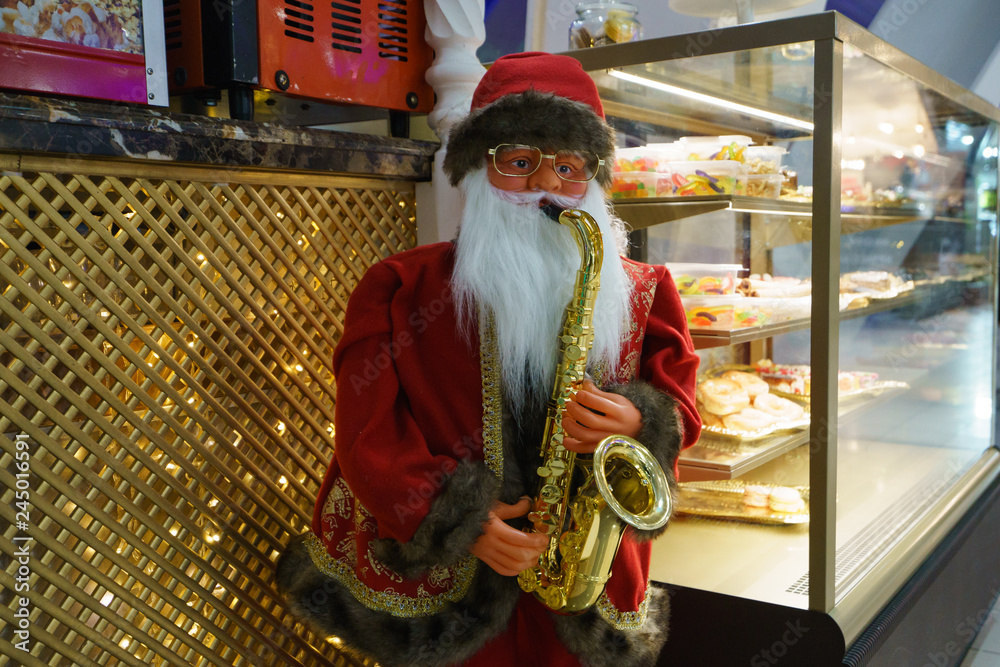 Image of Santa Claus - saxophonist on a city street at night