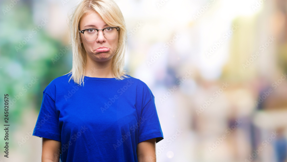 Young beautiful blonde woman wearing glasses over isolated background depressed and worry for distress, crying angry and afraid. Sad expression.