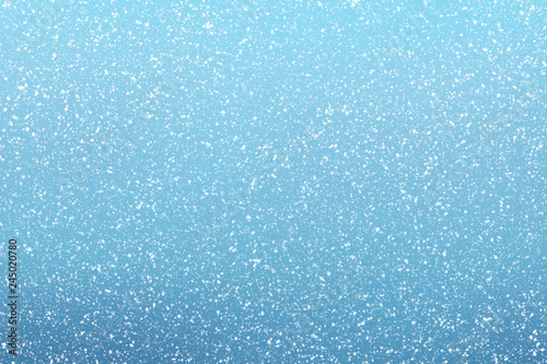 Snow falls on winter blue sky background