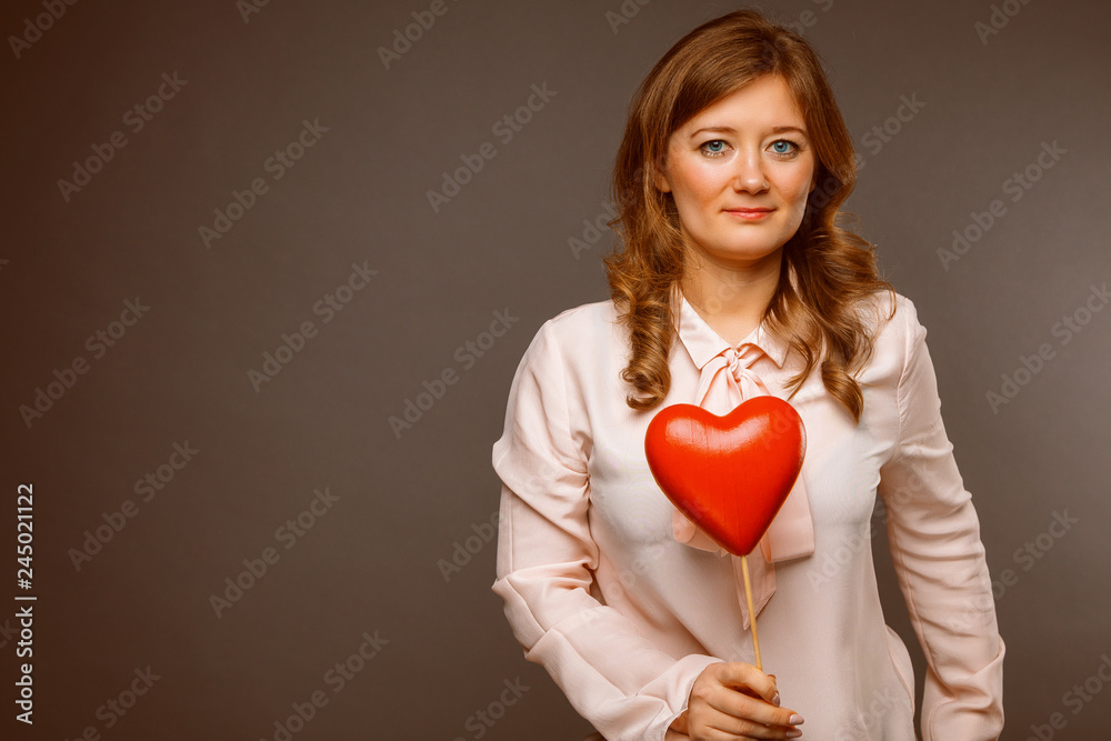 Young couple with heart shaped red balloons near grey wall Young couple with heart shaped red balloons near grey wall