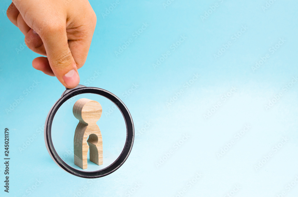 Φωτογραφία Magnifying glass is looking at the Wooden man with a void in the body in the form of a child