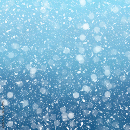 Snow falls on winter blue sky background