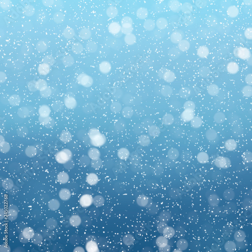 Snow falls on winter blue sky background