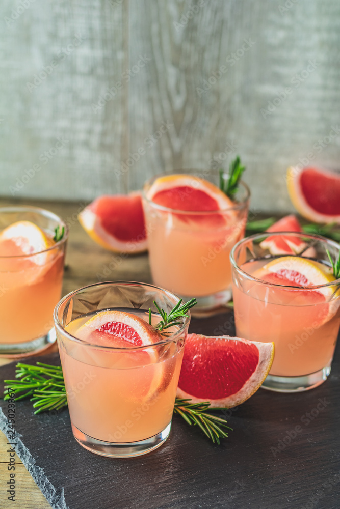 Pink alcoholic cocktail with grapefruit, ice and rosemary Pink alcoholic cocktail with grapefruit, ice and rosemary