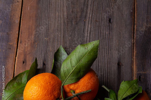 tangerines with leaves on pine boards photo