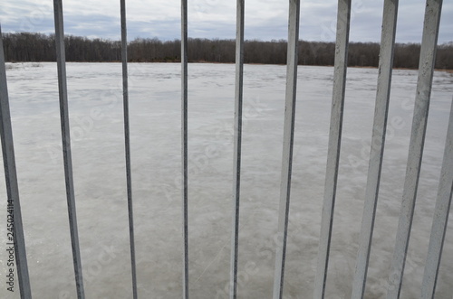 frozen lake or pond through metal bars