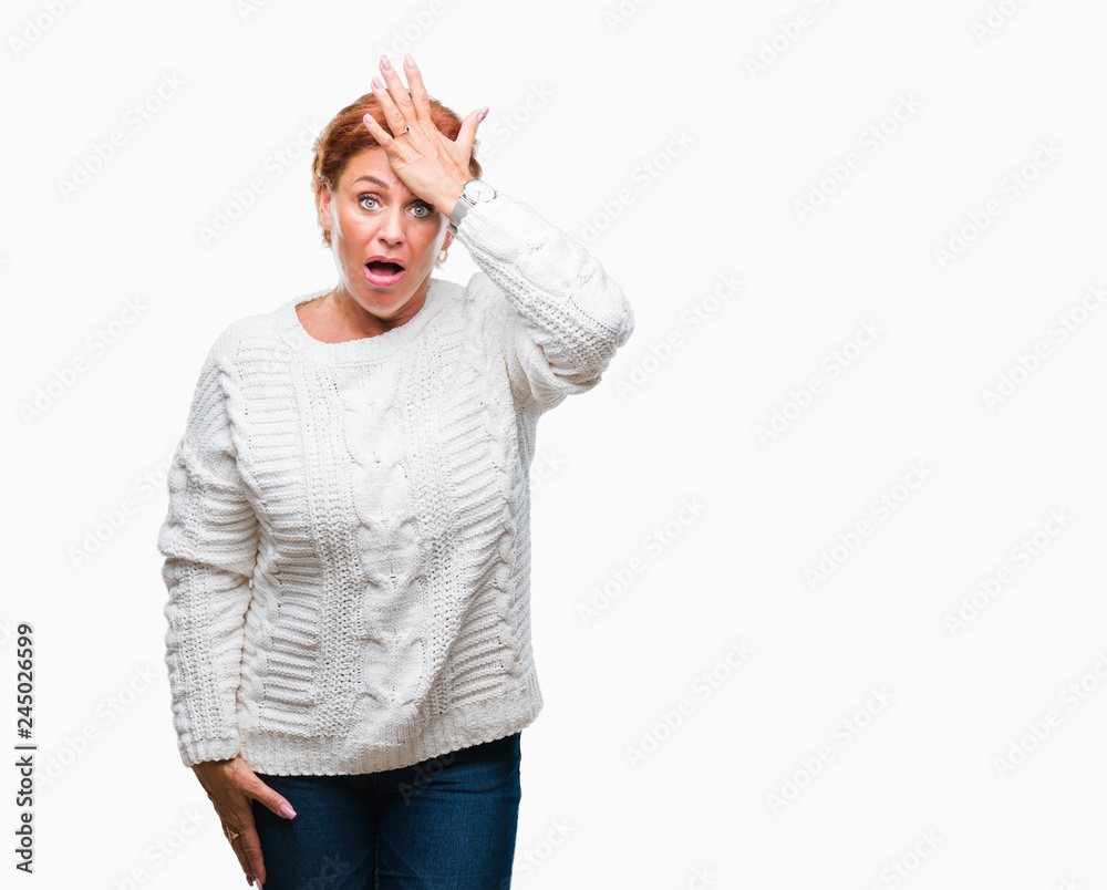 Atrractive senior caucasian redhead woman wearing winter sweater over isolated background surprised with hand on head for mistake, remember error. Forgot, bad memory concept. Atrractive senior caucasian redhead woman wearing winter sweater over isolated background surprised with hand on head for mistake, remember error. Forgot, bad memory concept.