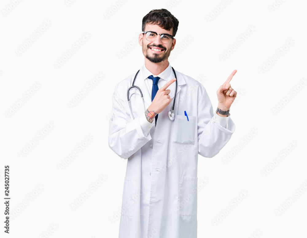 Young doctor man wearing hospital coat over isolated background smiling and looking at the camera pointing with two hands and fingers to the side. Young doctor man wearing hospital coat over isolated background smiling and looking at the camera pointing with two hands and fingers to the side.
