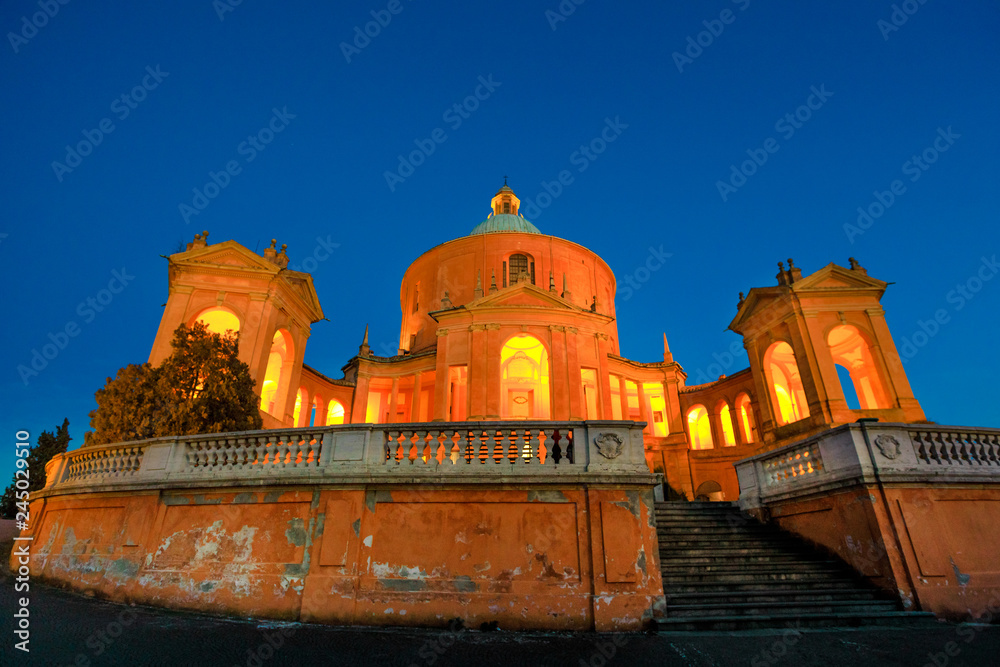Entrance of Sanctuary of Madonna di San Luca at blue hour. Basilica church of San Luca in Bologna, Emilia-Romagna, Italy illuminated by night. Famous landmark cityscape.