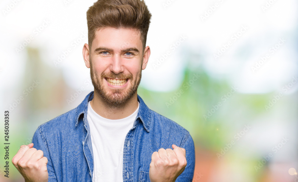 Young handsome blond man wearing casual denim jacket celebrating surprised and amazed for success with arms raised and open eyes. Winner concept.