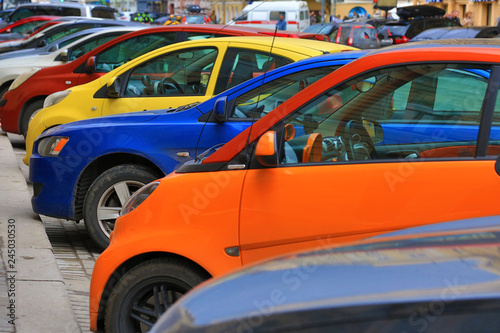 Colorful cars parked on the street, Yellow, blue, red, orange automobiles.