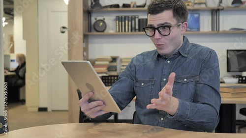 Man in Glasses Reacting to Loss while Using Tablet photo