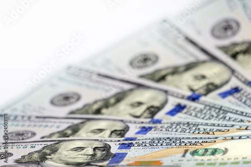 Shallow depth of field, small DOF, selective focus. New one hundred US dollar bills are like a fan. Blurred. Financial or business background for the designer.