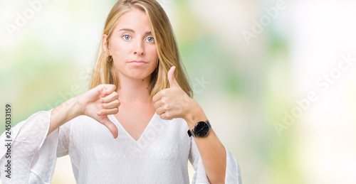Fototapeta Naklejka Na Ścianę i Meble -  Beautiful young elegant woman over isolated background Doing thumbs up and down, disagreement and agreement expression. Crazy conflict
