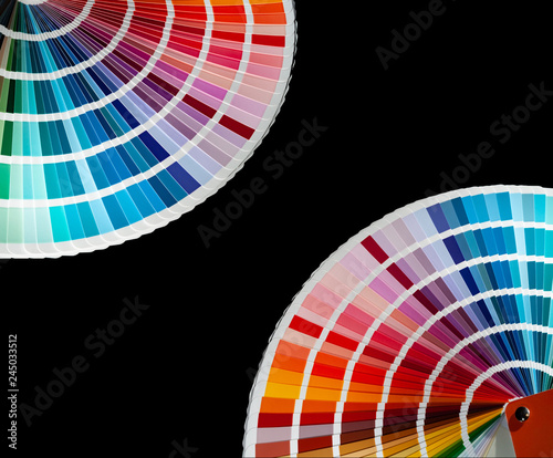 Two color fan decks with samples of various paint in the corners of image, isolated on a black background
