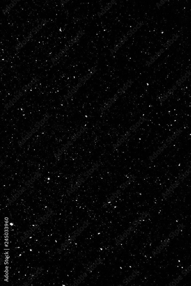 Real snow falling in a winter night. White snow on black background. Abstract elements to use in graphic design or as an overlay for other photos.