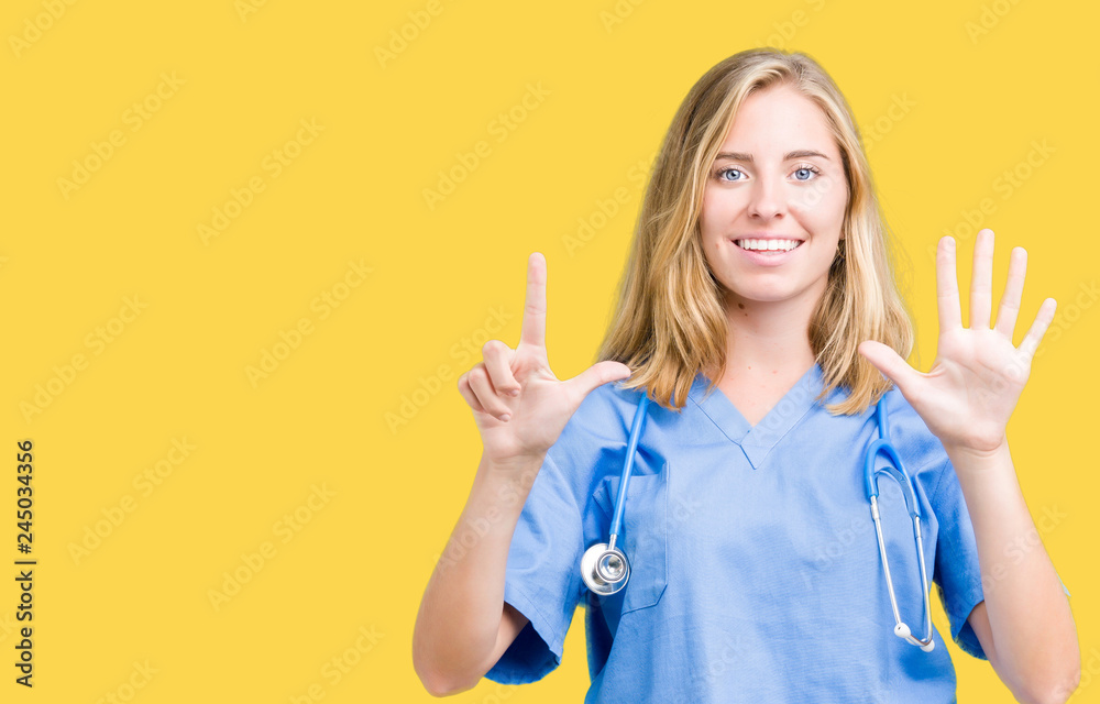 Beautiful young doctor woman wearing medical uniform over isolated background showing and pointing up with fingers number seven while smiling confident and happy. Beautiful young doctor woman wearing medical uniform over isolated background showing and pointing up with fingers number seven while smiling confident and happy.