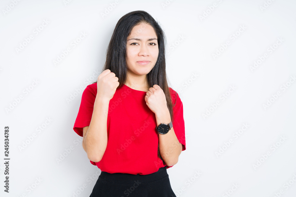 Beautiful brunette woman wearing red t-shirt over isolated background Ready to fight with fist defense gesture, angry and upset face, afraid of problem Beautiful brunette woman wearing red t-shirt over isolated background Ready to fight with fist defense gesture, angry and upset face, afraid of problem