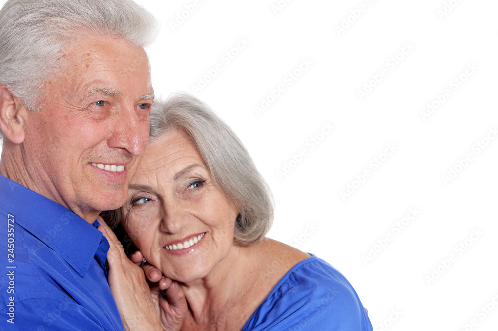 portrait of senior couple hugging on white background